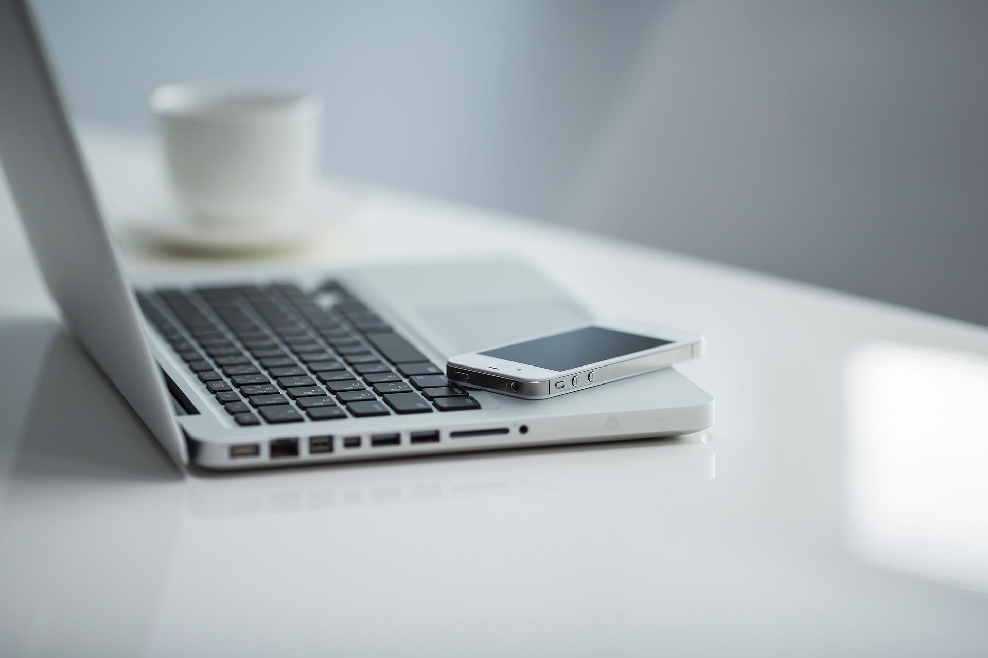 Laptop Smartphone und Kaffeetasse auf einem Tisch