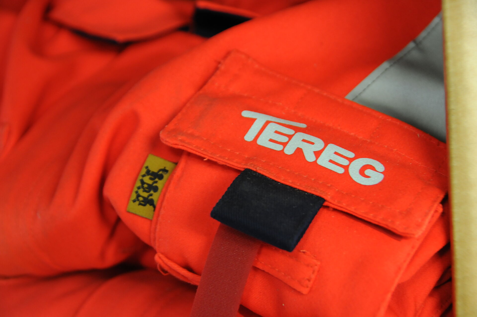 Nahaufnahme einer Orangefarbenen Jacke mit Tereg Logo